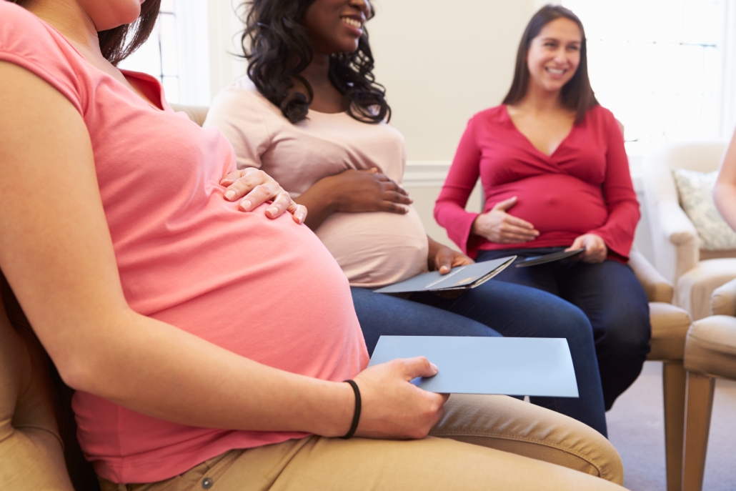 Three woman sitting in chairs at an ante natal class