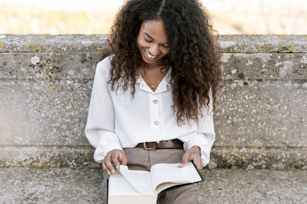 smiley-woman-enjoying-book-outdoors